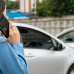 Image of someone speaking on a cellphone after a car collision